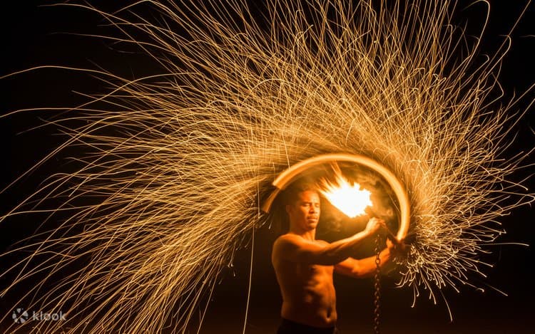 Fire performer creating a wheel of sparks during an Agafay night show